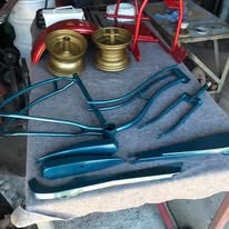 Teal powder coated bike parts laid out with gold rims