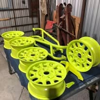 Neon yellow powder coated wheels and roll bar in the workshop